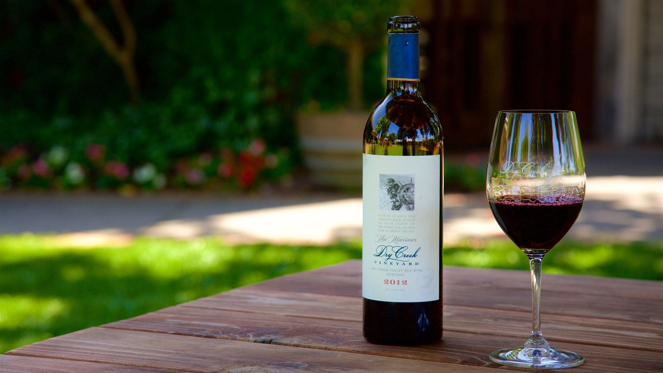 Dry Creek Vineyard bottle and a glass of red wine on a garden table