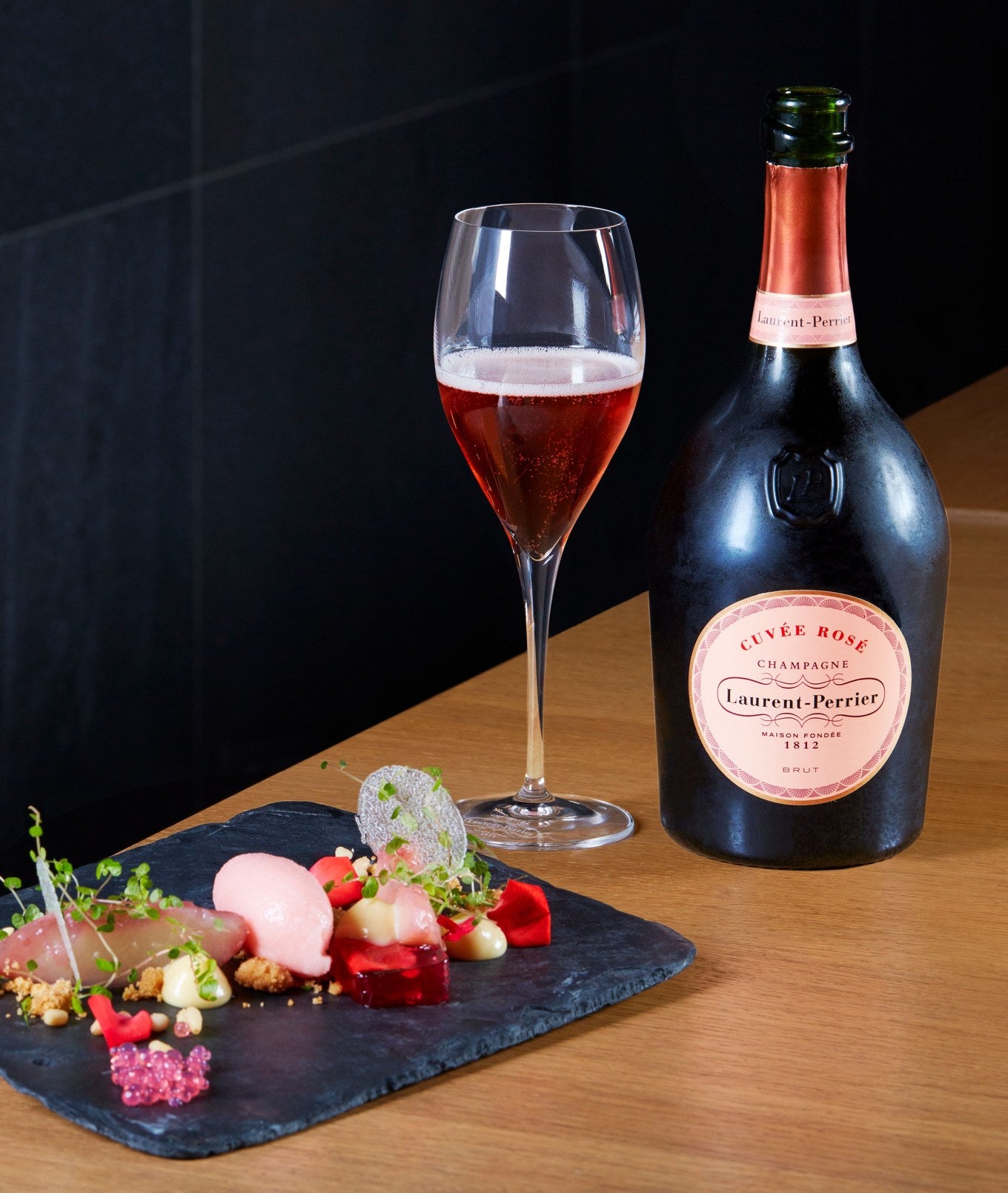 Laurent-Perrier Cuvee Rose Champagne poured beside a plate of canapes